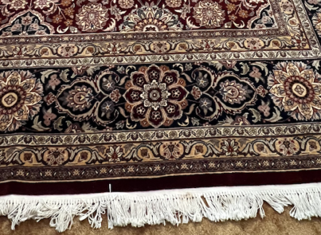 A Persian-style area rug undergoing rug combing