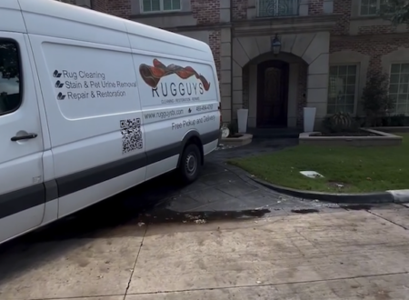 Rug Guys delivery van parked in front of a luxurious brick home, advertising rug cleaning, stain removal, and repair services with free pickup and delivery options