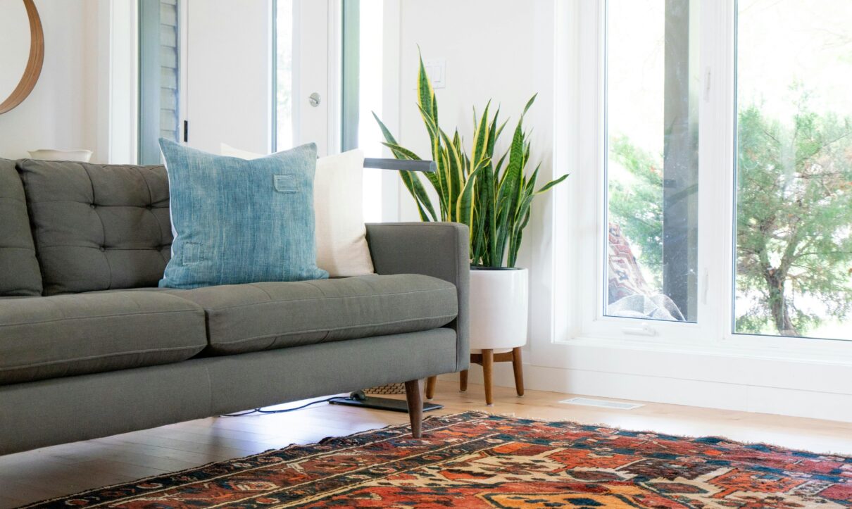 Colorful Oriental rug in a modern living room with sunlight shining through large windows – professionally cleaned to restore vibrant patterns and colors.