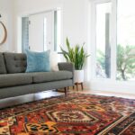 Colorful Oriental rug in a modern living room with sunlight shining through large windows – professionally cleaned to restore vibrant patterns and colors.